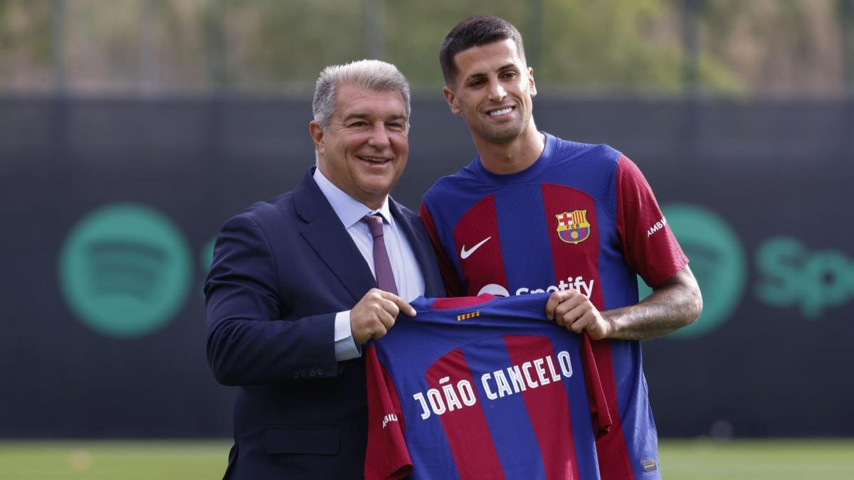 Joao Cancelo posing with Joan Laporta